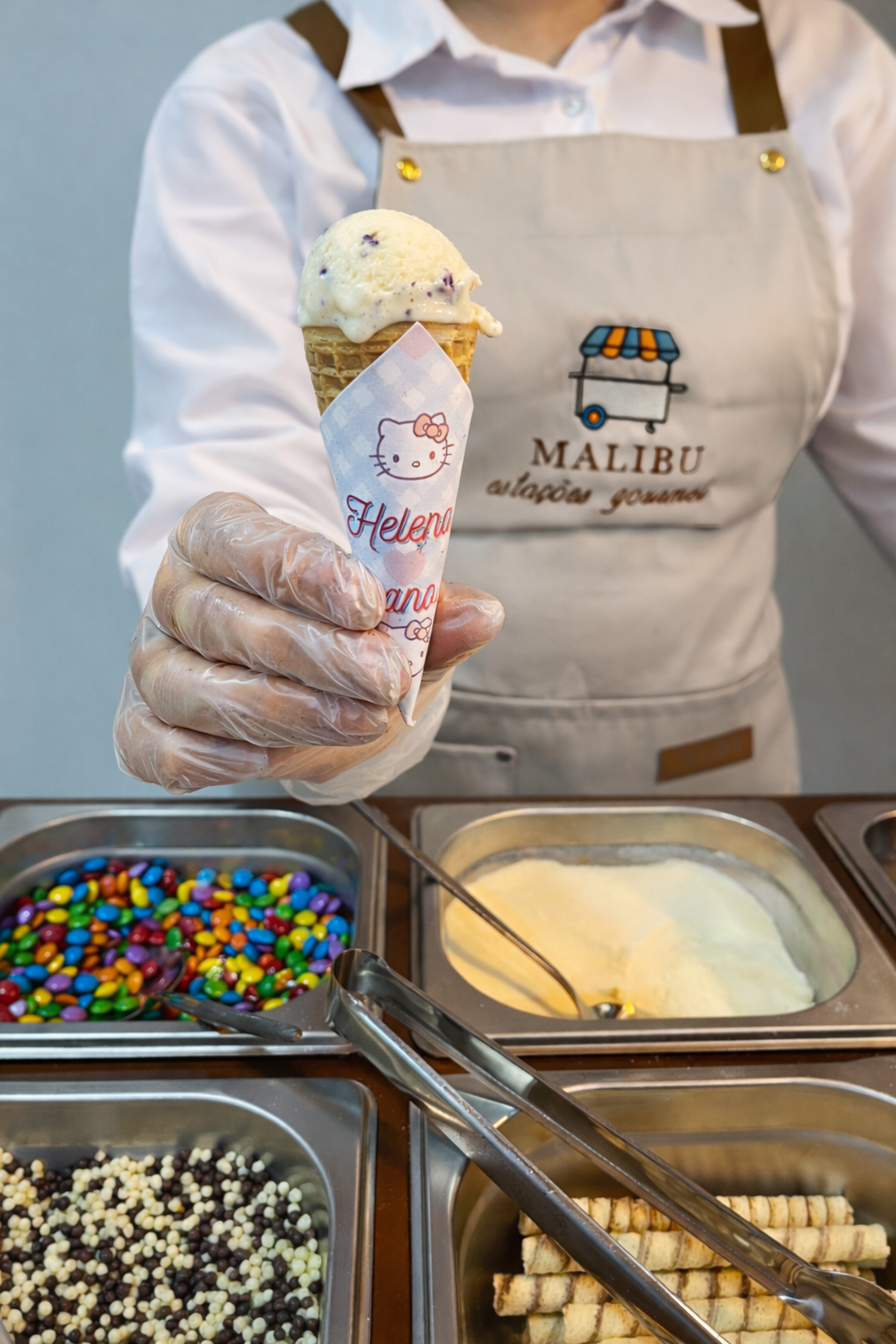 Atendente da Malibu Estações Gourmet entregando casquinha de sorvete com embalagem personalizada